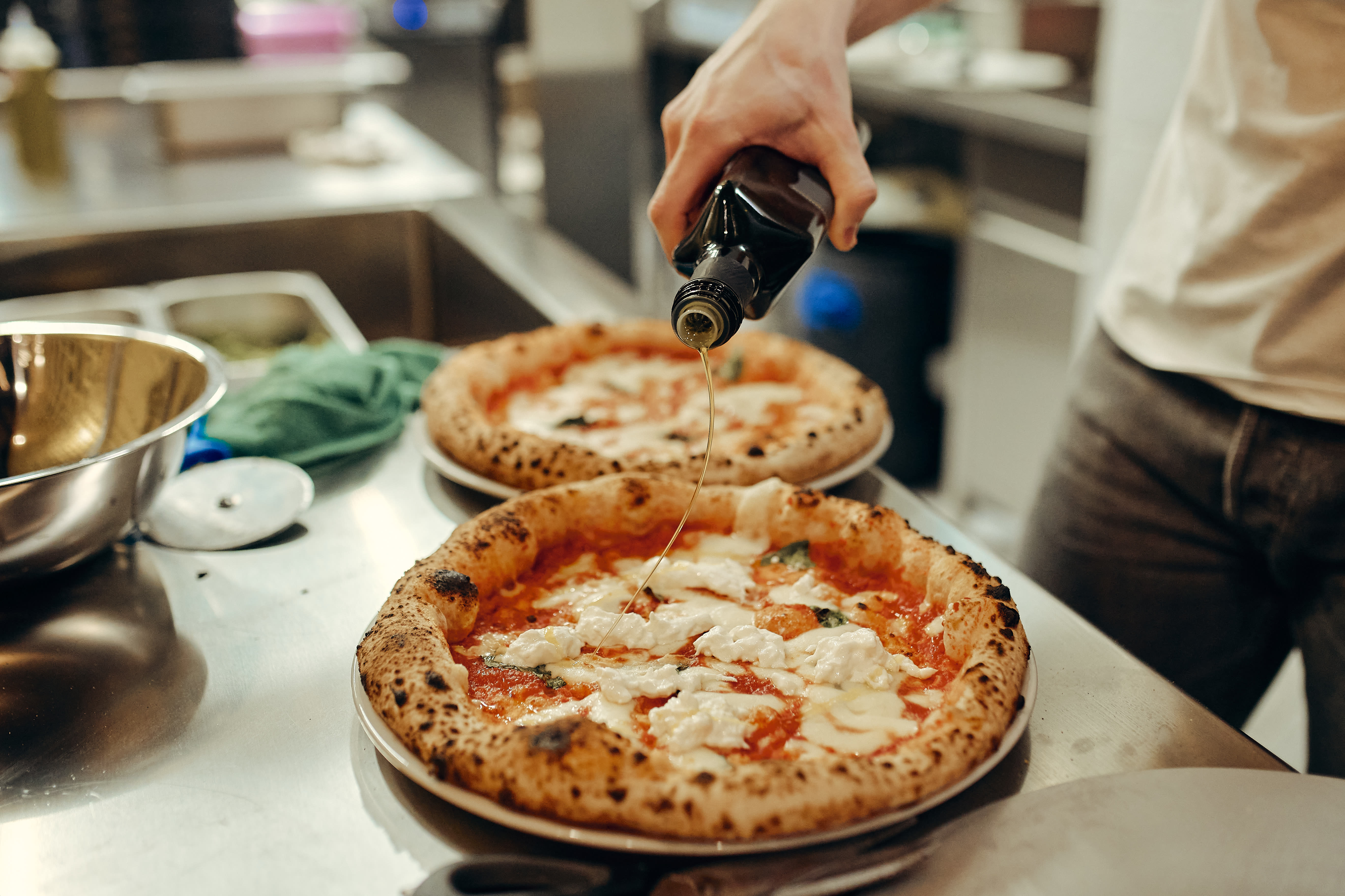 Napolitanska pica z oljčnim oljem in svežim nadevom.