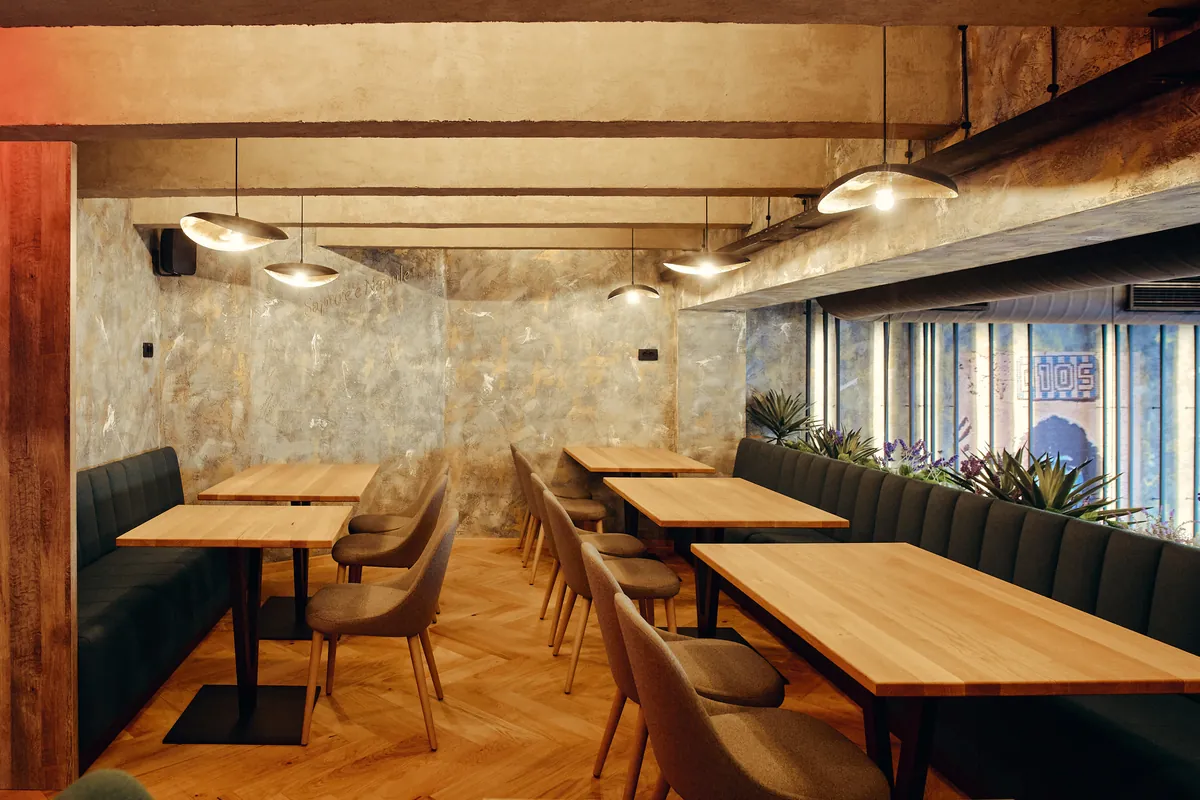 Jedilnica: zeleni banjeti, sivi stoli, napis Sapore e Napoli, talni vzorec.