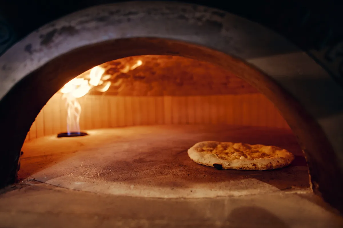 Pica v ognju znotraj zlatega oboda peči.