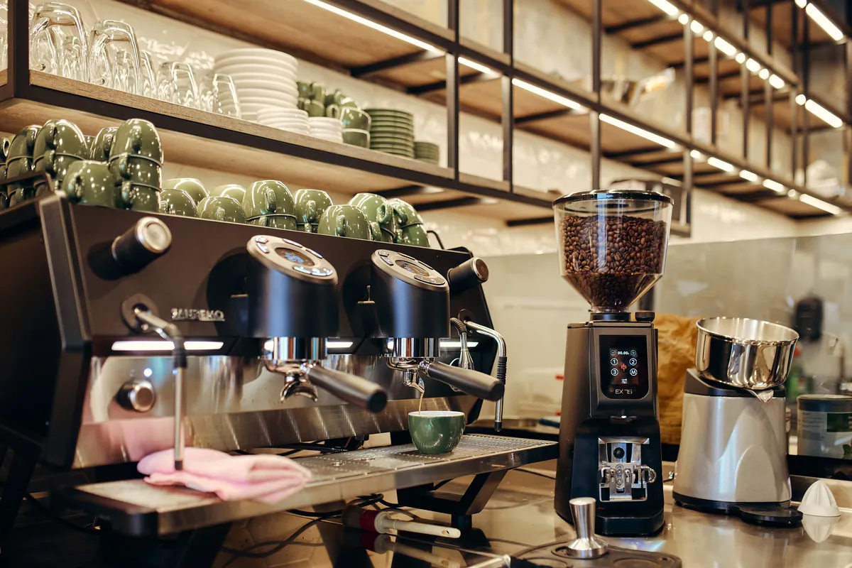 Kavna postaja: kavni avtomat Sanremo, mlinček, zeleni lončki.